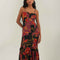 model wearing black tank maxi dress with red and purple flowers with gold accents