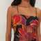 up close of model wearing black tank maxi dress with red and purple flowers with gold accents