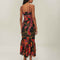 back view of model wearing black tank maxi dress with red and purple flowers with gold accents