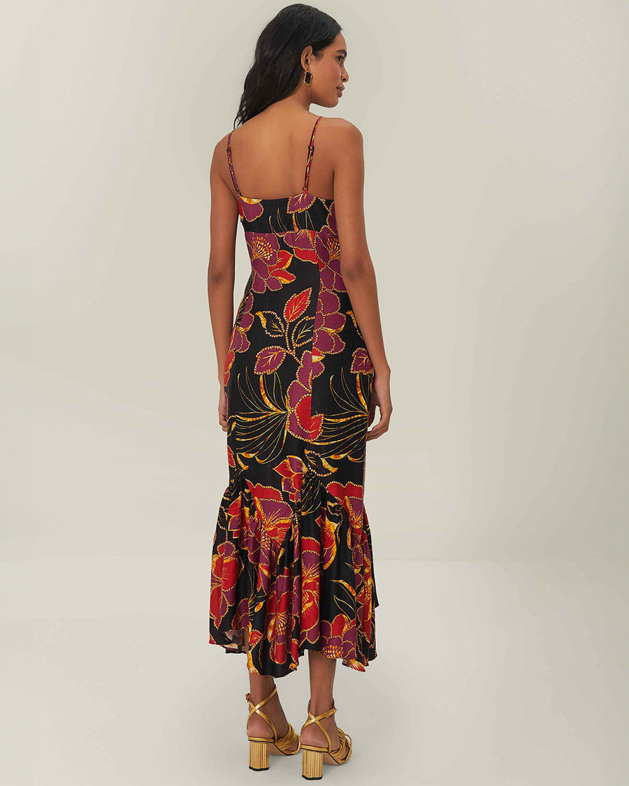 back view of model wearing black tank maxi dress with red and purple flowers with gold accents