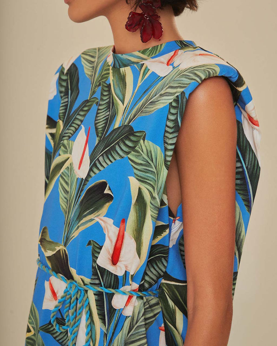 side view of model wearing blue mini t-shirt dress with white anthurium flower print and tie waist