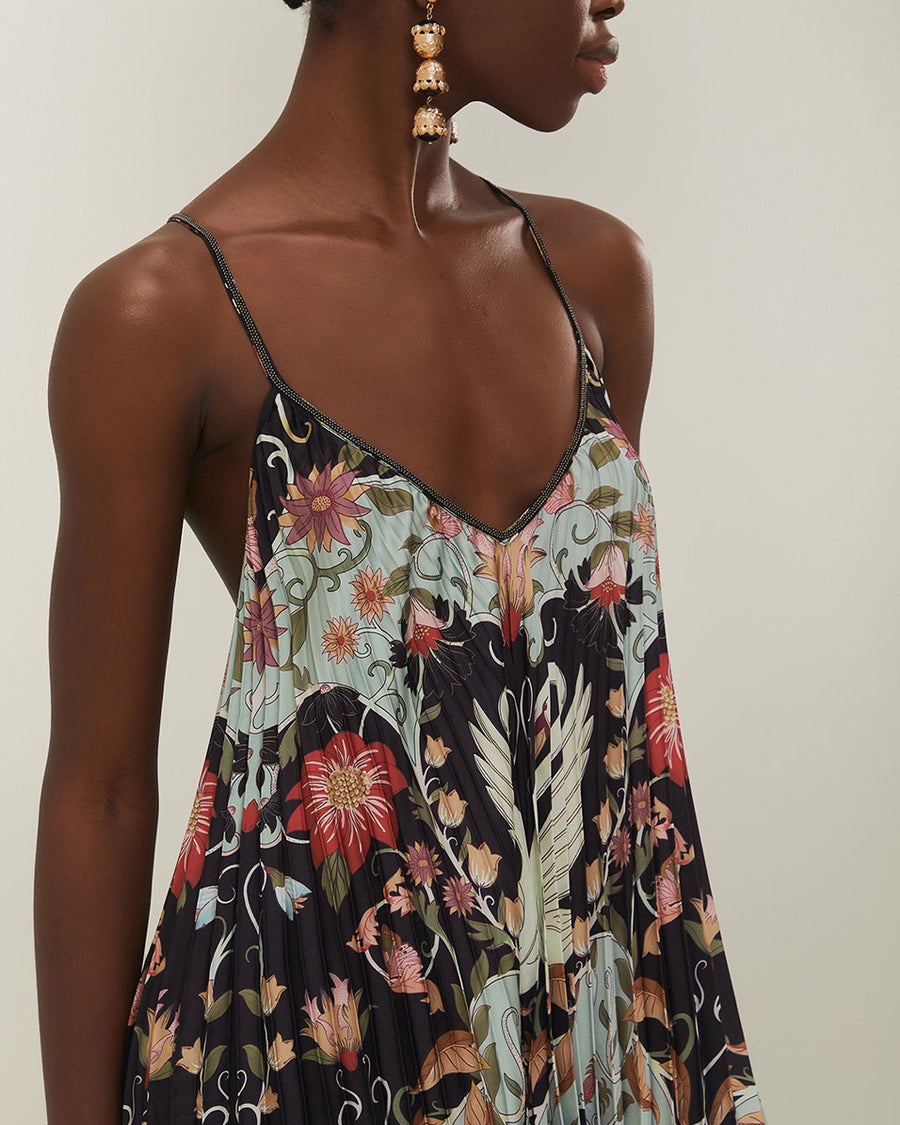 up close of v-neckline of light blue and black pleated midi dress with floral and swan design