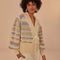 model wearing cream cropped cardigan with puff sleeves with colorful woven stripe pattern