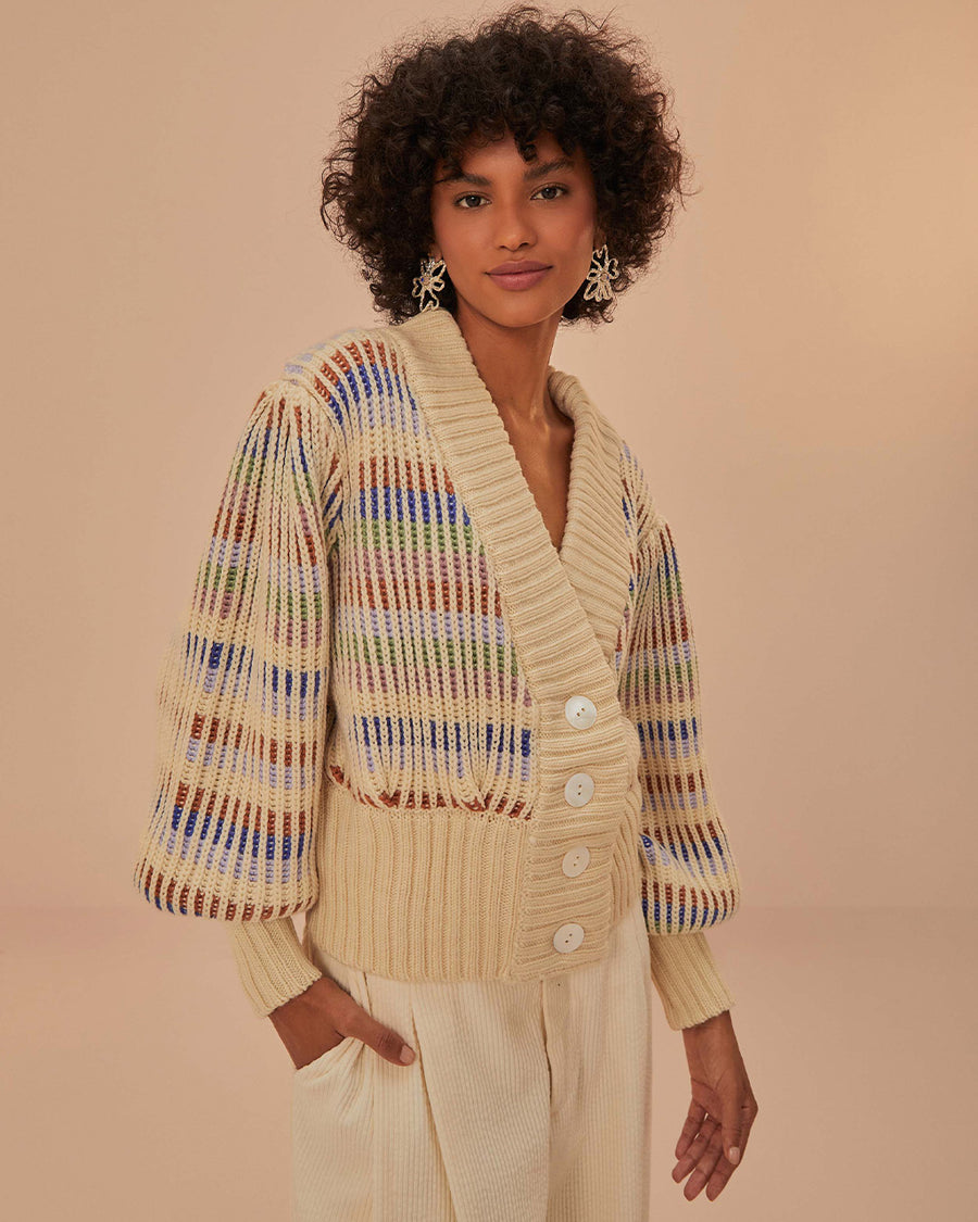 model wearing cream cropped cardigan with puff sleeves with colorful woven stripe pattern