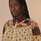 up close of model wearing cream button down blouse with button sleeves, collar, and colorful floral trim