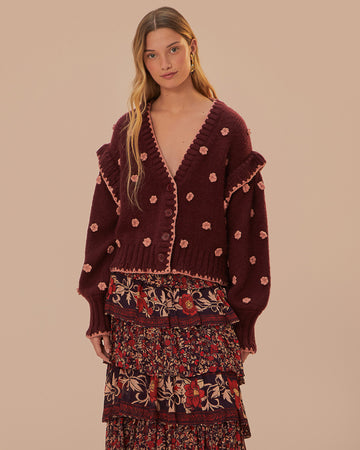 model wearing brown cardigan with pink crochet flowers, ruffle on the sleeves and slight boxy cropped fit