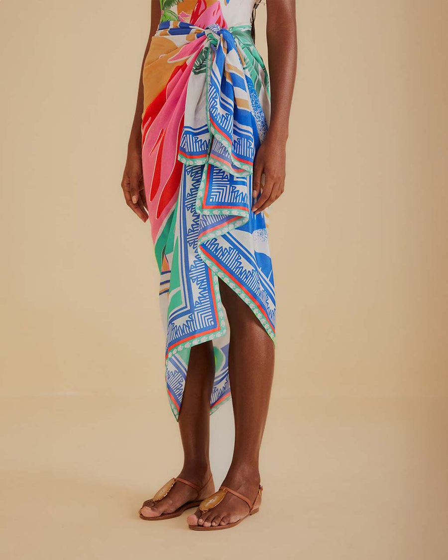 up close of model wearing cream sarong with colorful vintage beach poster print