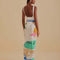 back view of model wearing cream sarong with colorful vintage beach poster print