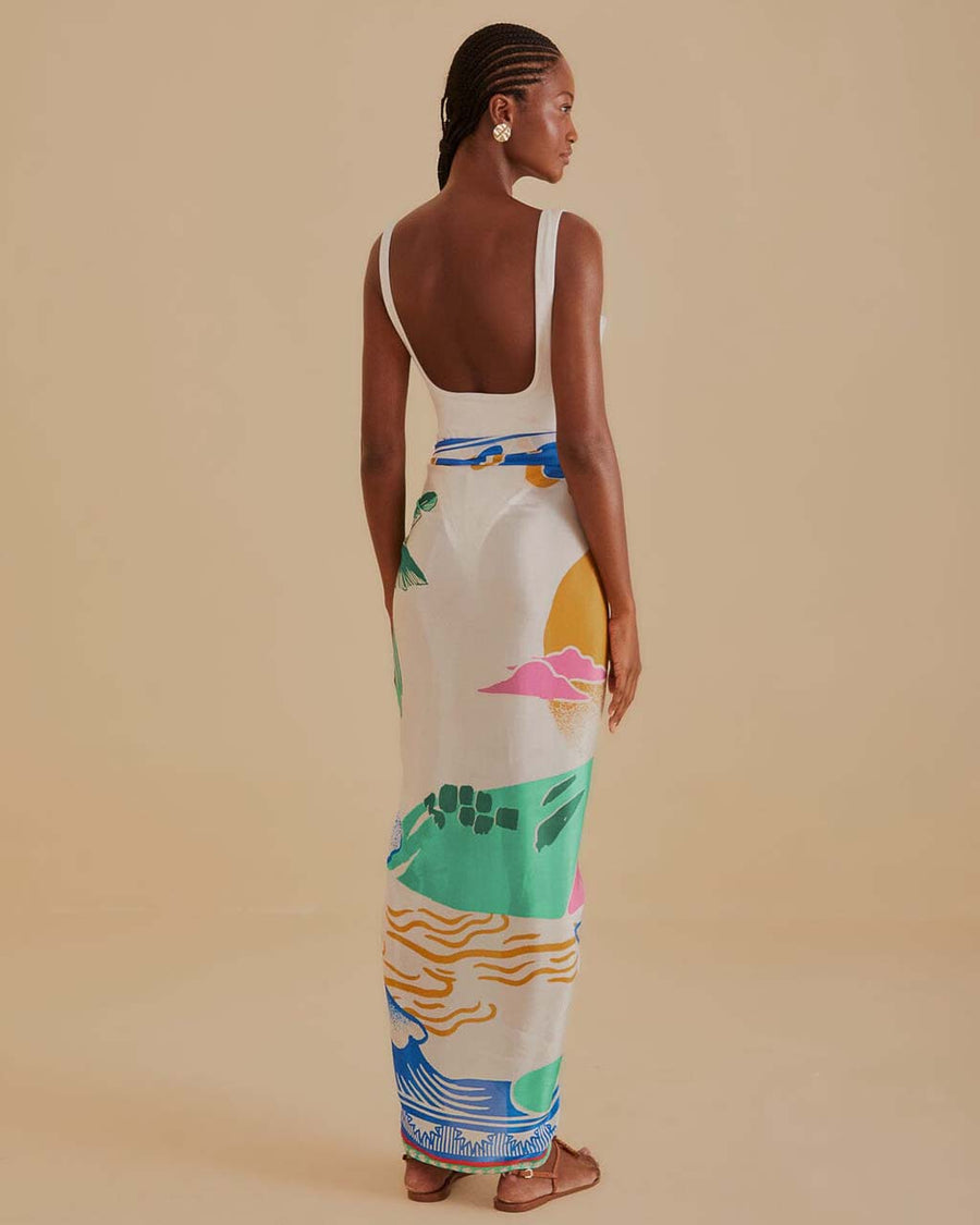 back view of model wearing cream sarong with colorful vintage beach poster print