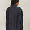 back view of model wearing shimmery blue denim jacket with button front and patch front pockets