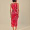 back view of model wearing and pink and red abstract floral midi dress with tank sleeves