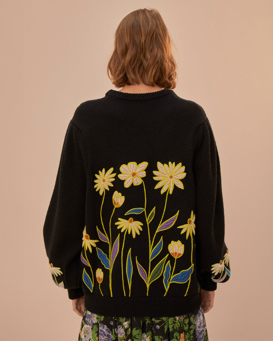 back view of model wearing black relaxed fit sweater with embroidered 'farm rio' and flowers