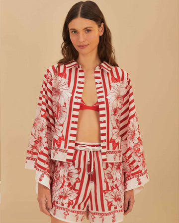 model wearing cropped white and red stripe button down top with flared sleeves and floral and chain charm print