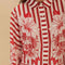 model wearing buttoned cropped white and red stripe button down top with flared sleeves and floral and chain charm print