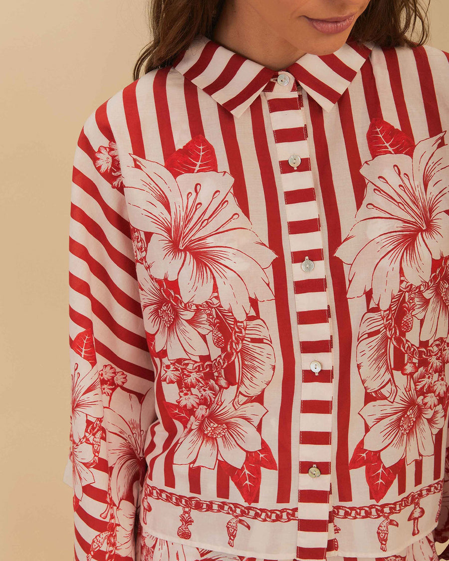 model wearing buttoned cropped white and red stripe button down top with flared sleeves and floral and chain charm print