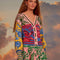 model wearing colorful bird print cardigan with ric rac detail on the arms and bodice and striped trim