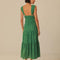 back view of model wearing emerald green eyelet midi dress with deep V neckline and o-ring straps