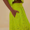 side view of model wearing lime green eyelet maxi skirt with pockets