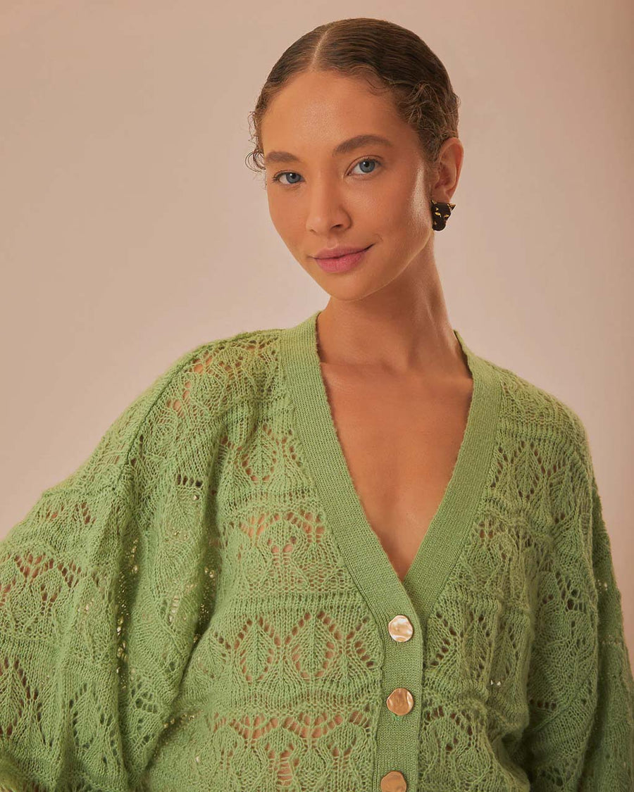 up close of model wearing light green textured open knit cardigan