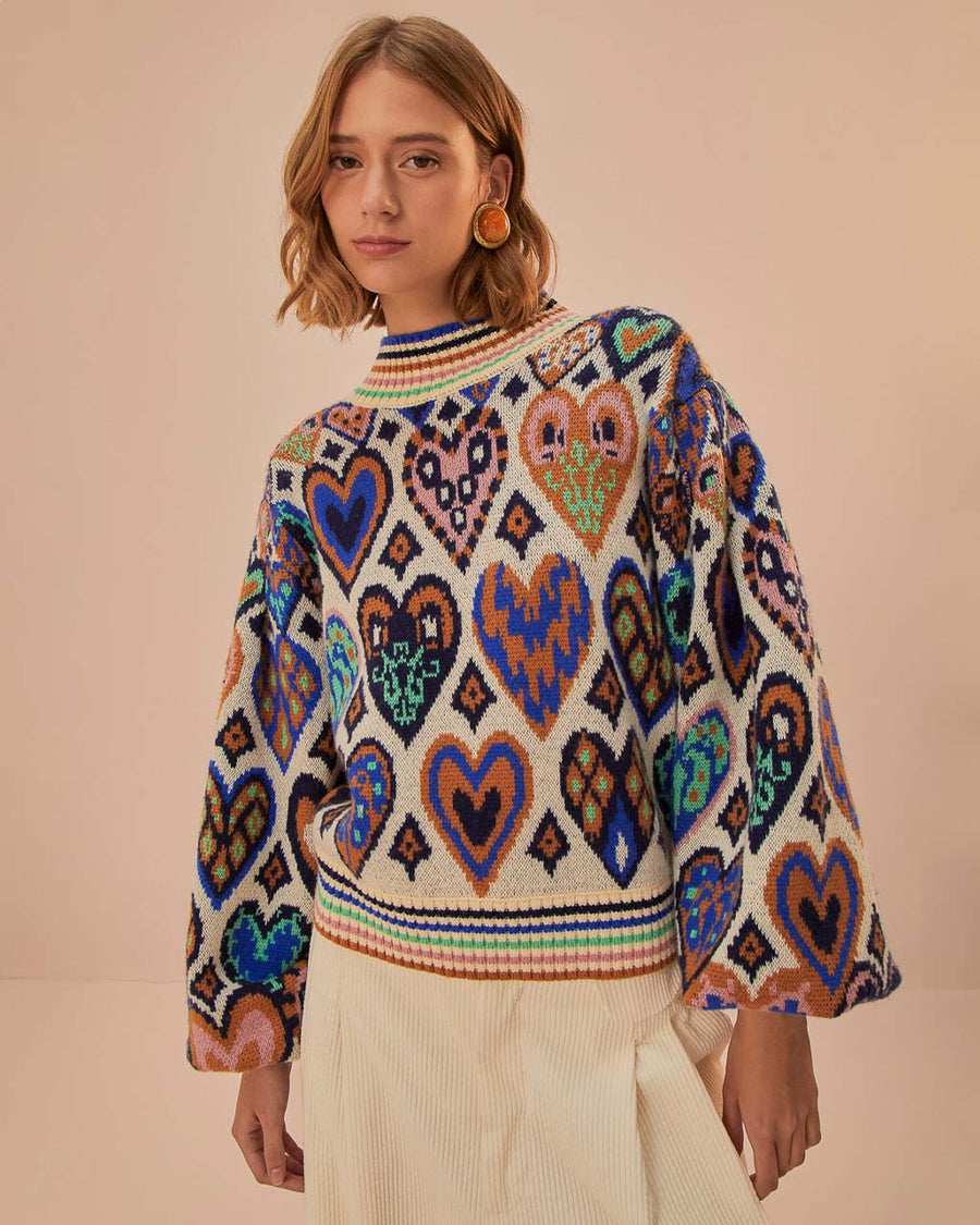 model wearing sand ground with colorful ikat and heart pattern with rainbow stripe mock neckline and bottom hem