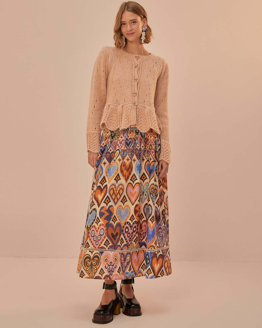 model wearing sand midi skirt with colorful abstract heart and ikat prints