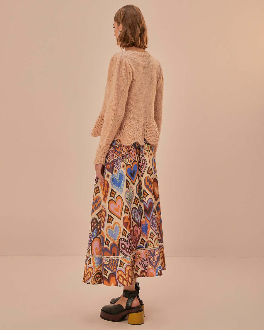 back view of model wearing sand midi skirt with colorful abstract heart and ikat prints