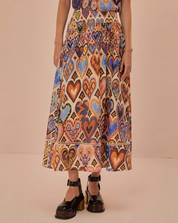 model wearing sand midi skirt with colorful abstract heart and ikat prints