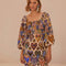 model wearing square neck mini dress with sand ground and colorful ikat heart print and long puff sleeves