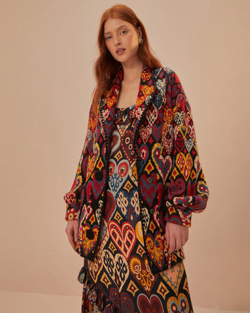 model wearing colorful abstract heart knit cardigan sweater with slight blouson sleeves and blazer collar