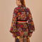 back view of model wearing colorful abstract heart knit cardigan sweater with slight blouson sleeves and blazer collar