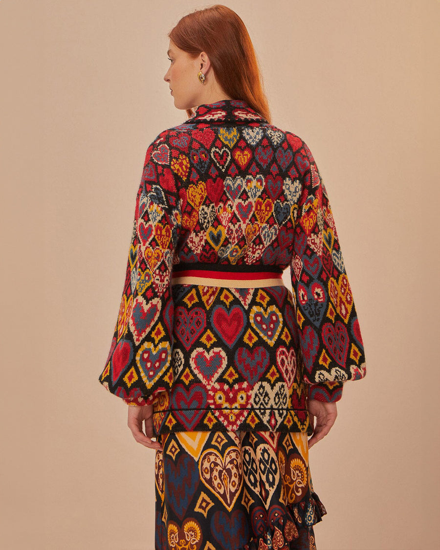 back view of model wearing colorful abstract heart knit cardigan sweater with slight blouson sleeves and blazer collar