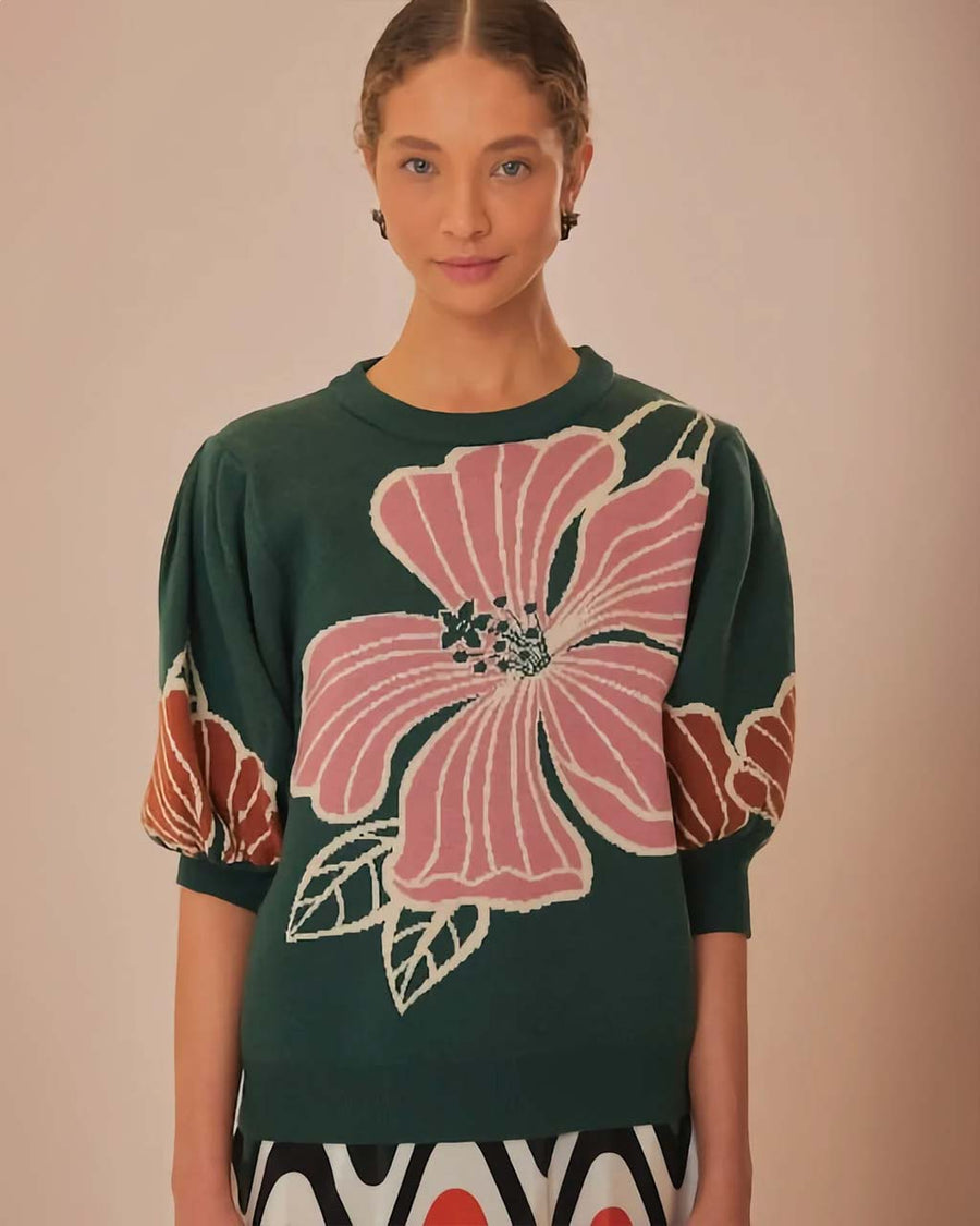 model wearing green short sleeve sweater with burnt rust and pink flower print