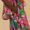 side view of model wearing colorful tropical floral print with beaded tassel tie waist and side pockets