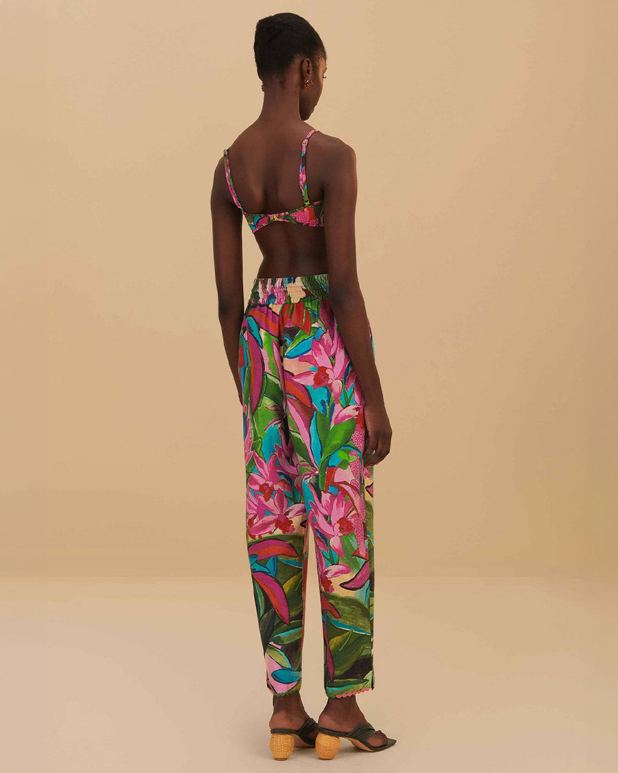 back view of model wearing colorful tropical floral print with beaded tassel tie waist and side pockets