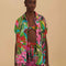 model wearing colorful tropical floral print with button front and pink and green mini tassel detail on the placket and sleeves