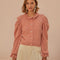 model wearing light pink cardigan with button front, ruched sleeves with ruffle detail and slight scalloped collar