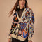 model wearing cream cardigan with black trim and colorful leopard and abstract heart print