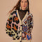 model wearing cream cardigan with black trim and colorful leopard and abstract heart print