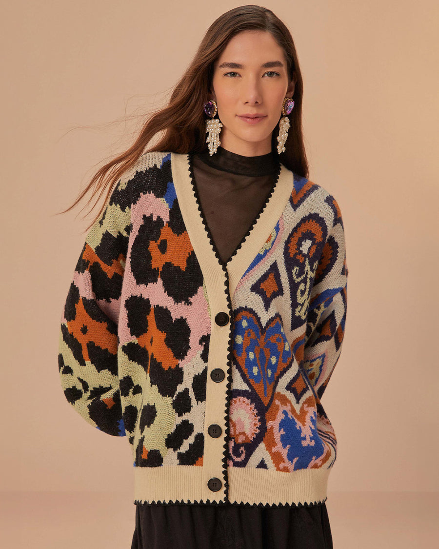 model wearing cream cardigan with black trim and colorful leopard and abstract heart print