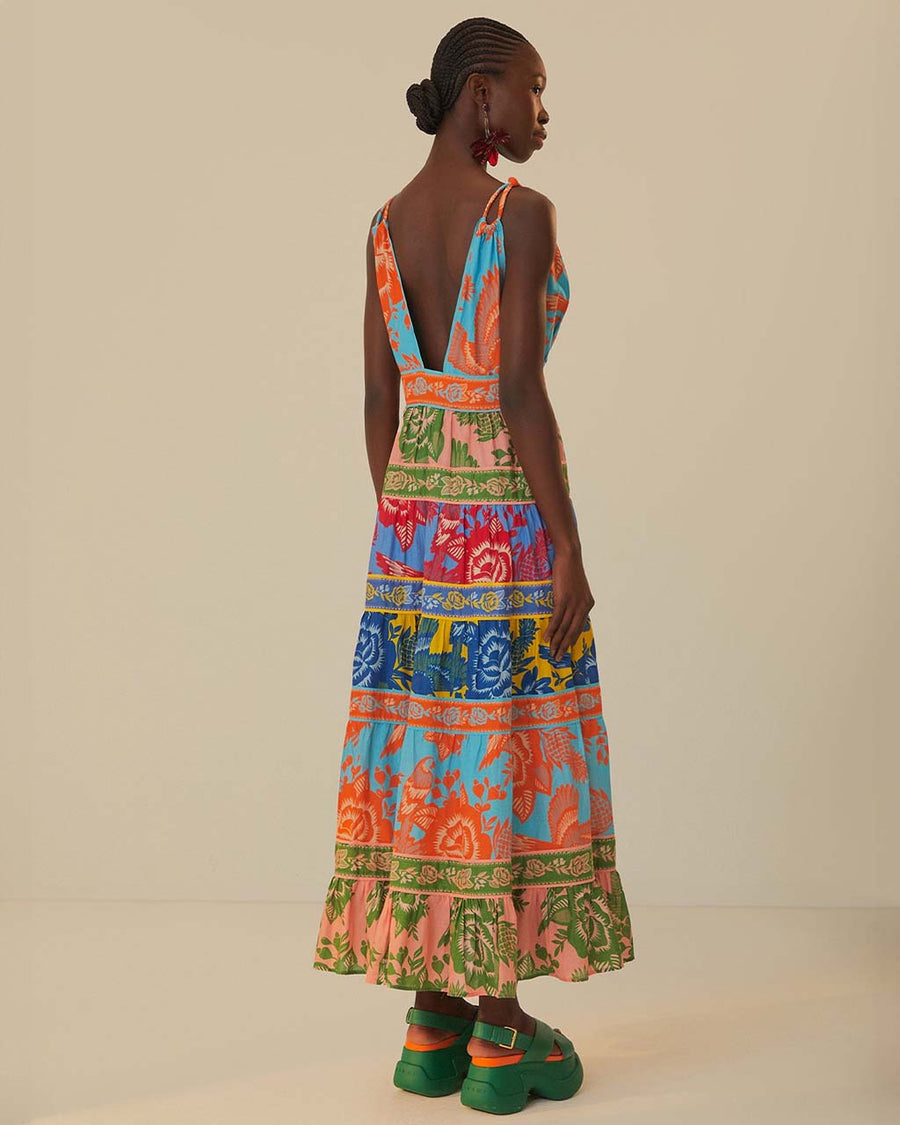 back view of model wearing colorful floral stripe midi dress with deep v and braided straps