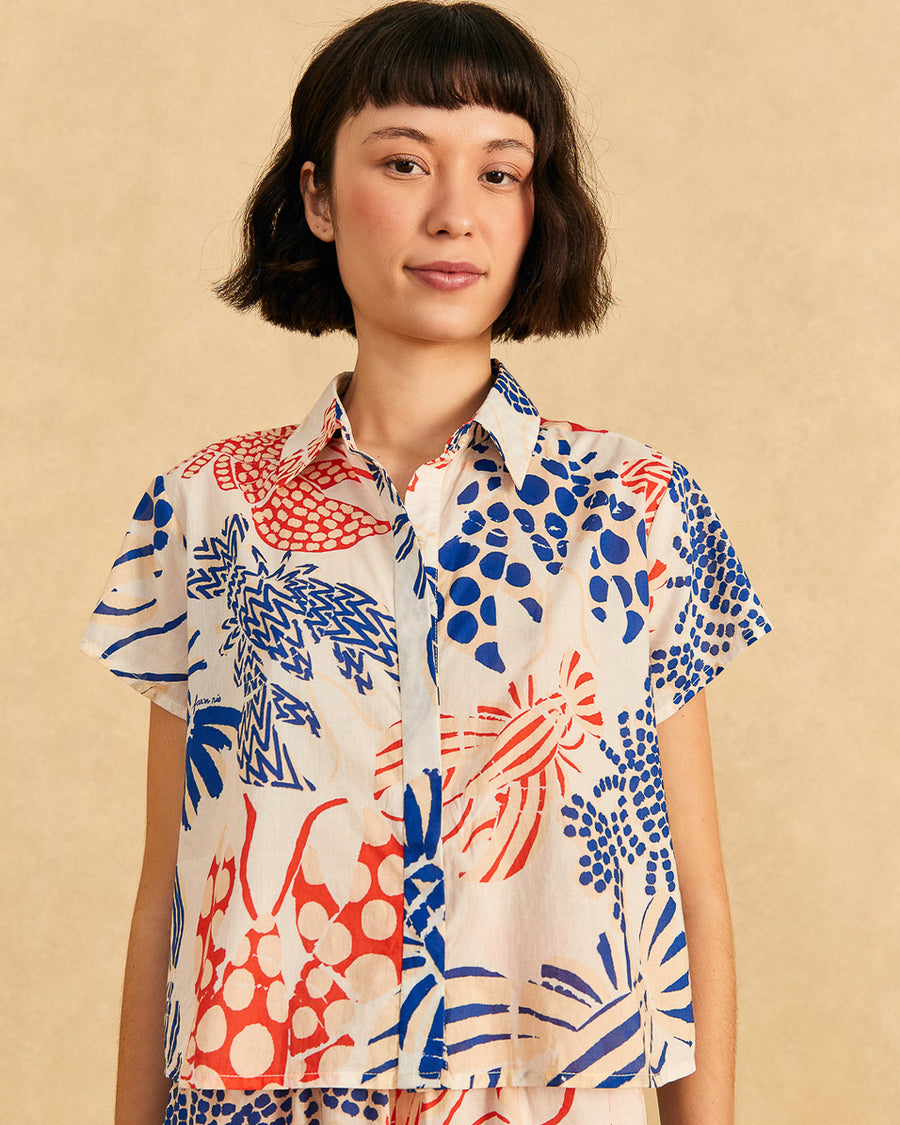 model wearing off white short sleeve button down top with blue and red abstract lobster print