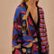 side view of model wearing split cardigan with blue abstract mushroom print and red, blue and black wavy print