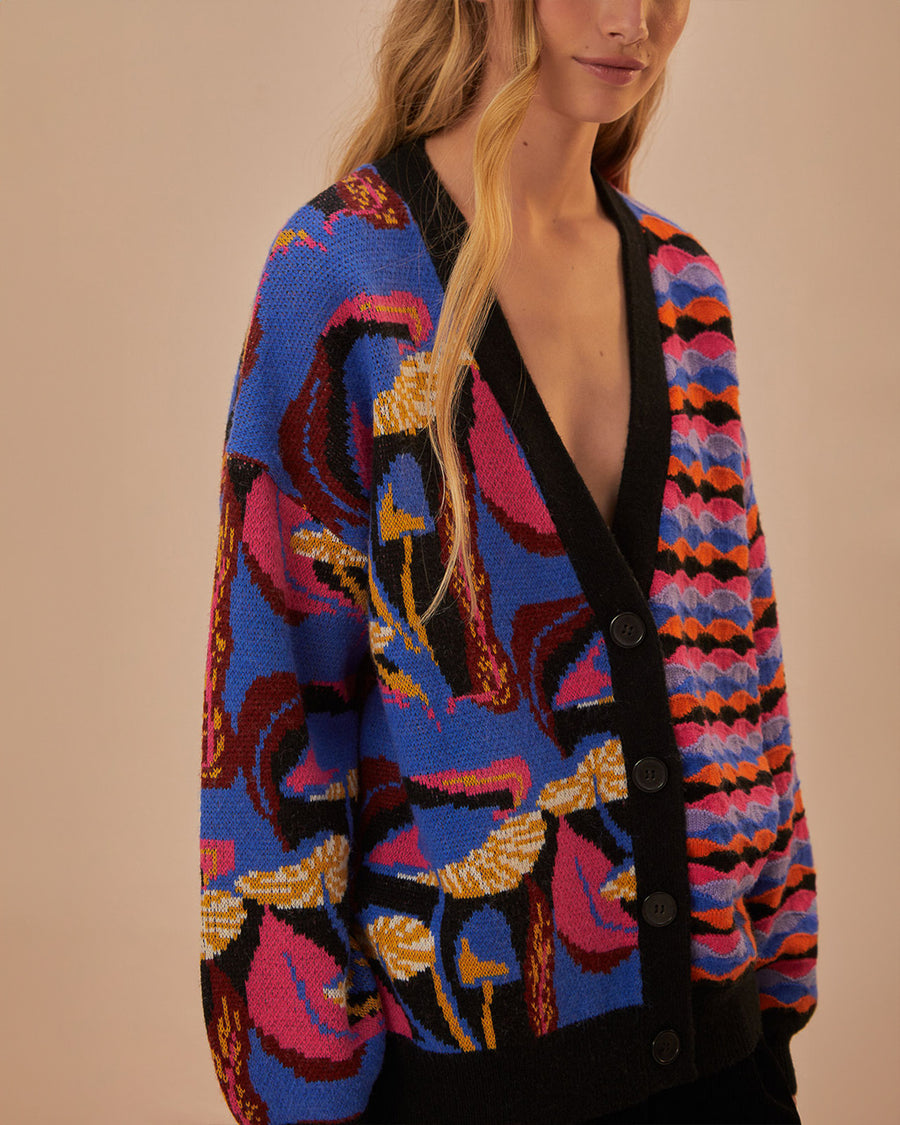 side view of model wearing split cardigan with blue abstract mushroom print and red, blue and black wavy print