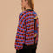 back view of model wearing split cardigan with blue abstract mushroom print and red, blue and black wavy print