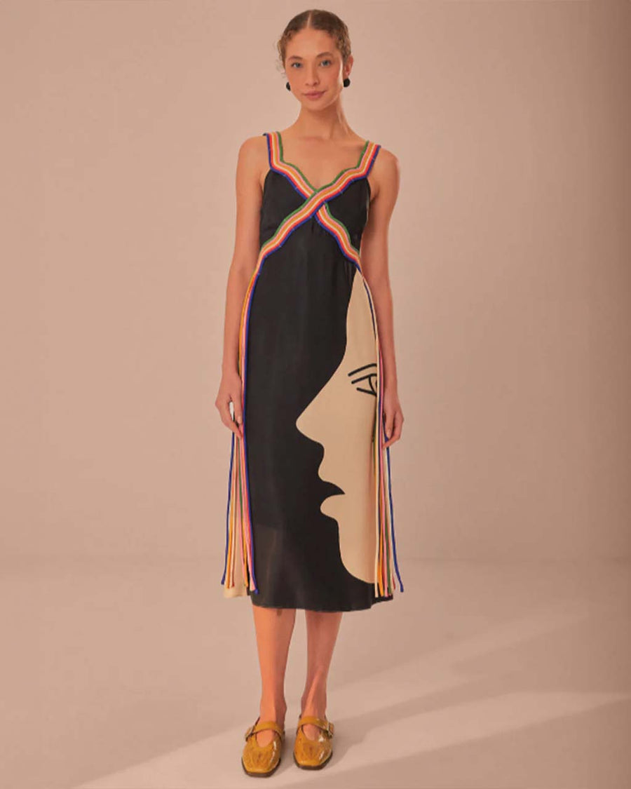 model wearing black midi dress with cream face silhouette on the side and colorful rope trim along the straps and bodice 