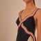 up close of model wearing black midi dress with cream face silhouette on the side and colorful rope trim along the straps and bodice