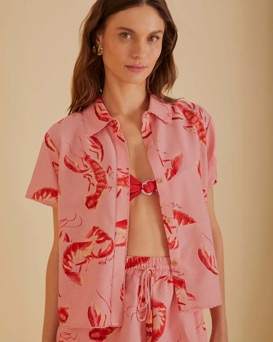 model wearing pink button down short sleeve top with all over lobster print