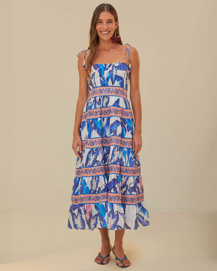 model wearing white midi dress with blue foliage print, pink floral stripes, and tie straps with beaded ends