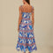 back view of model wearing white midi dress with blue foliage print, pink floral stripes, and tie straps with beaded ends