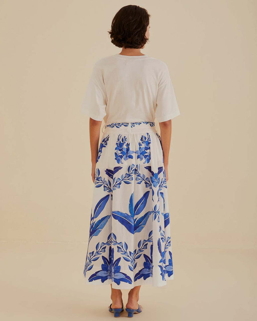 back view of model wearing white midi skirt with blue leaf print and tie waist